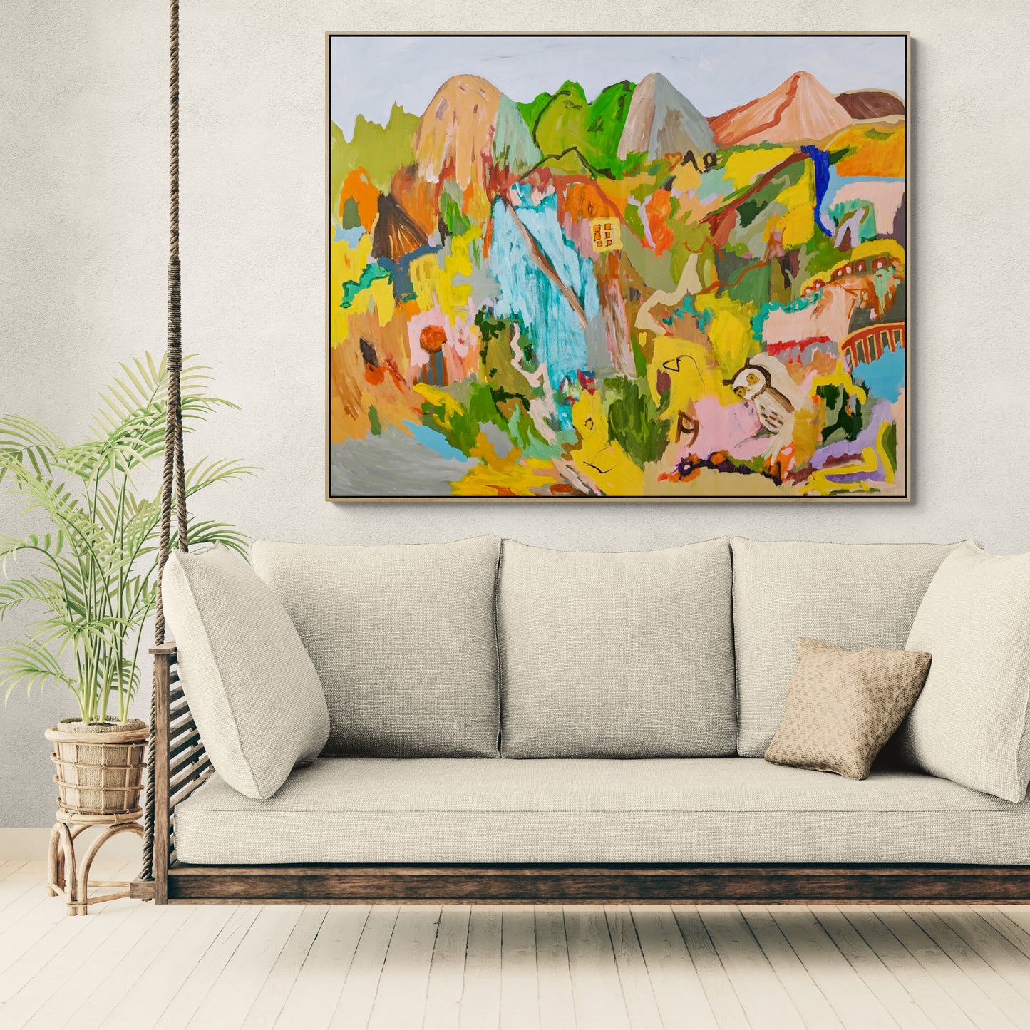 Colorful abstract painting above a beige sofa in a room with a plant.